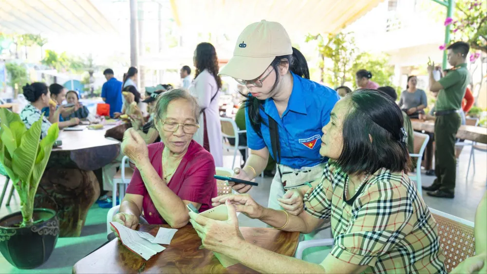 Đoàn viên thanh niên hướng dẫn người dân sử dụng công nghệ số trên điện thoại