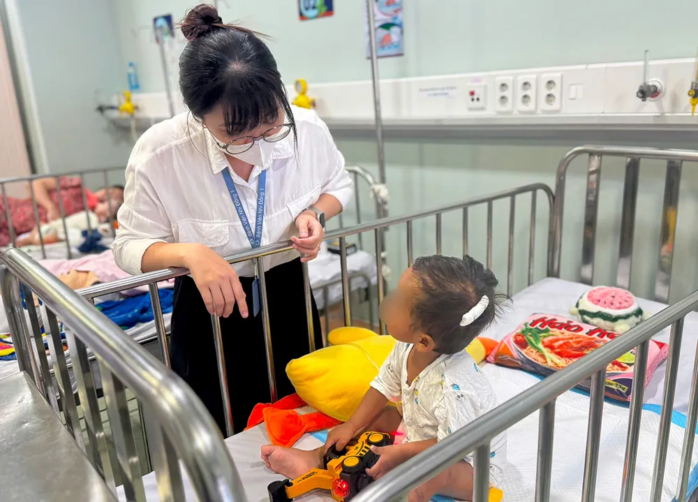 Bé N.G.K. làm quen với nhân viên công tác xã hội tại Bệnh viện Nhi đồng 1 TPHCM (ẢNH: BVCC)