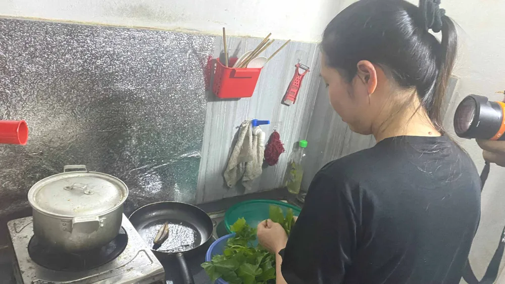 Nữ công nhân nấu bữa tối muộn sau giờ tăng ca tại phòng trọ gần khu công nghiệp Thái Nguyên. Ảnh: PHÚC HẬU 