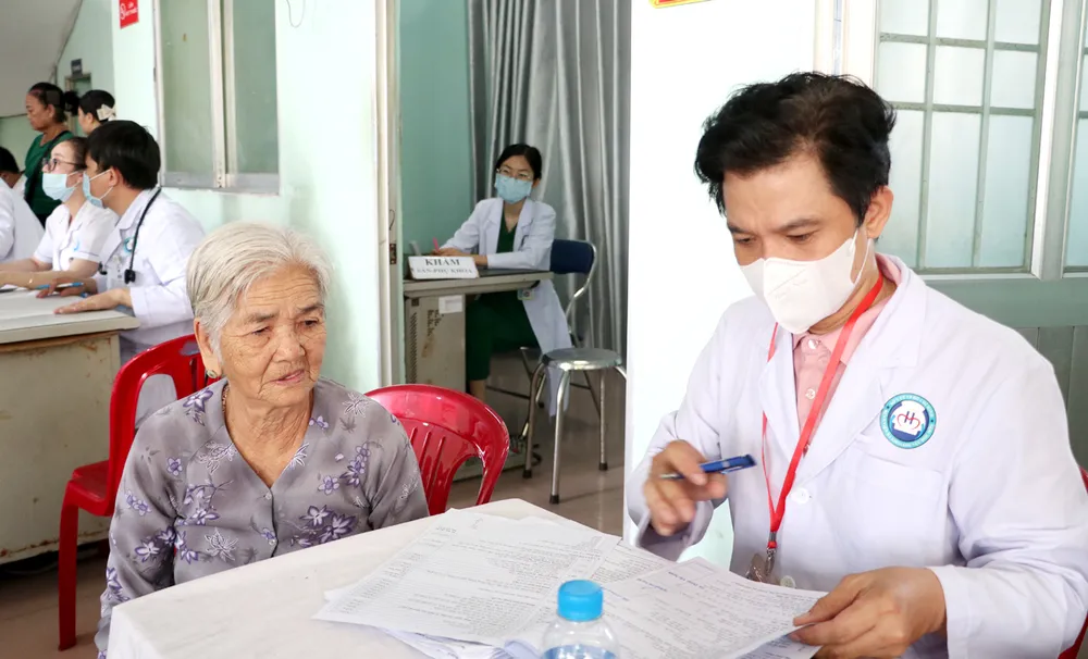 Bác sĩ Trạm y tế xã Bà Điểm khám sức khỏe miễn phí cho người dân (ẢNH: ĐÔNG SƠN)