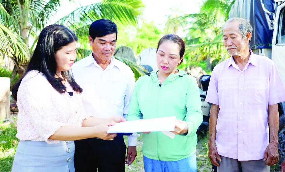 Đại diện Hội Liên hiệp Phụ nữ xã Hòa Vang (TP Đà Nẵng) vận động người dân thôn Cẩm Toại Trung giải phóng mặt bằng phục vụ dự án cải tạo, nâng cấp quốc lộ 14B (ẢNH: XUÂN QUỲNH)