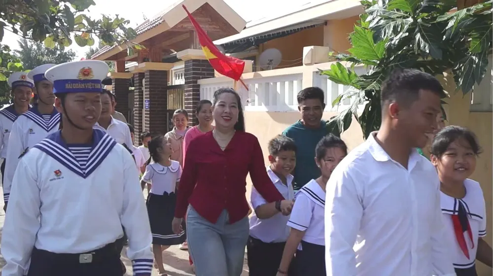 Cán bộ, chiến sĩ, phụ huynh Đảo Đá Tây hân hoan đưa các em học sinh đến trường.jpg