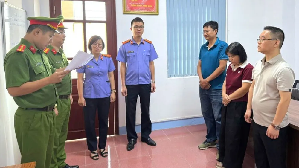 Đại diện Cơ quan Cảnh sát điều tra tống đạt quyết định tố tụng tới các bị can. Ảnh: CÔNG AN CUNG CẤP