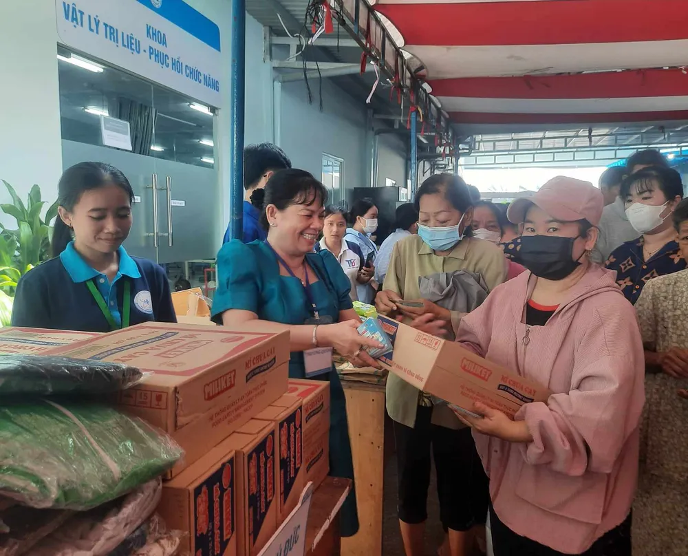 Thân nhân người bệnh có hoàn cảnh khó khăn nhận quà từ một gian hàng tại Phiên chợ 0 đồng