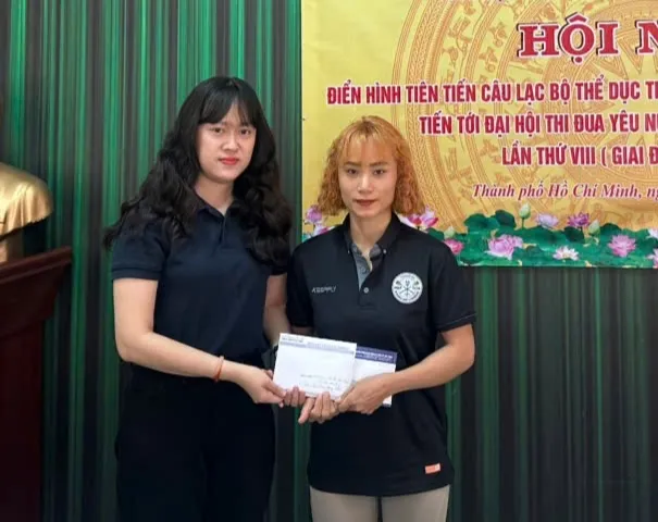 PV Báo SGGP trao tiền của bạn đọc hỗ trợ đến chị Nguyễn Thị Hường (phải, vợ của HLV Võ Văn Tìm). Ảnh: THANH TÙNG