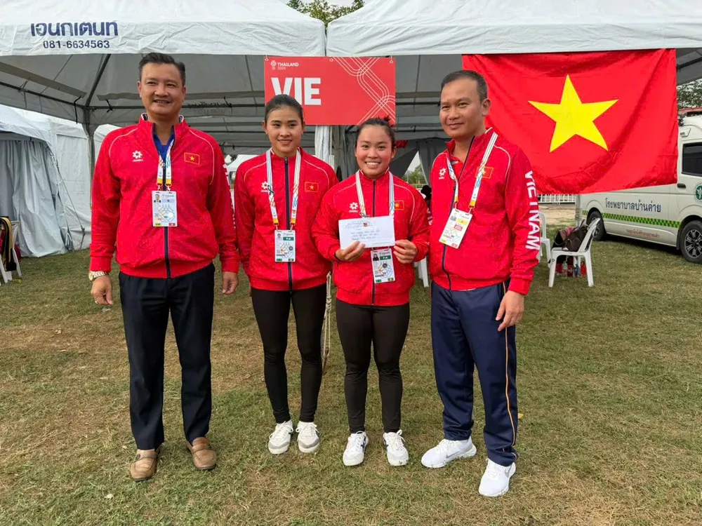 Trưởng đoàn thể thao Việt Nam tại SEA Games 33 Nguyễn Hồng Minh (bìa phải) trao thưởng nóng cho 2 tuyển thủ canoeing giành HCV đầu tiên. Ảnh: DŨNG PHƯƠNG