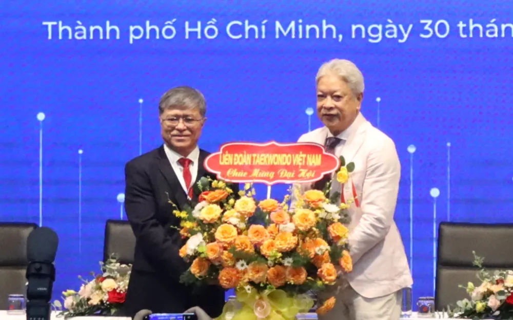Ông Nguyễn Văn Hiếu (trái) nhận hoa chúc mừng từ Chủ tịch Liên đoàn Taekwondo Việt Nam Trương Ngọc Để. Ảnh: THANH TÙNG 
