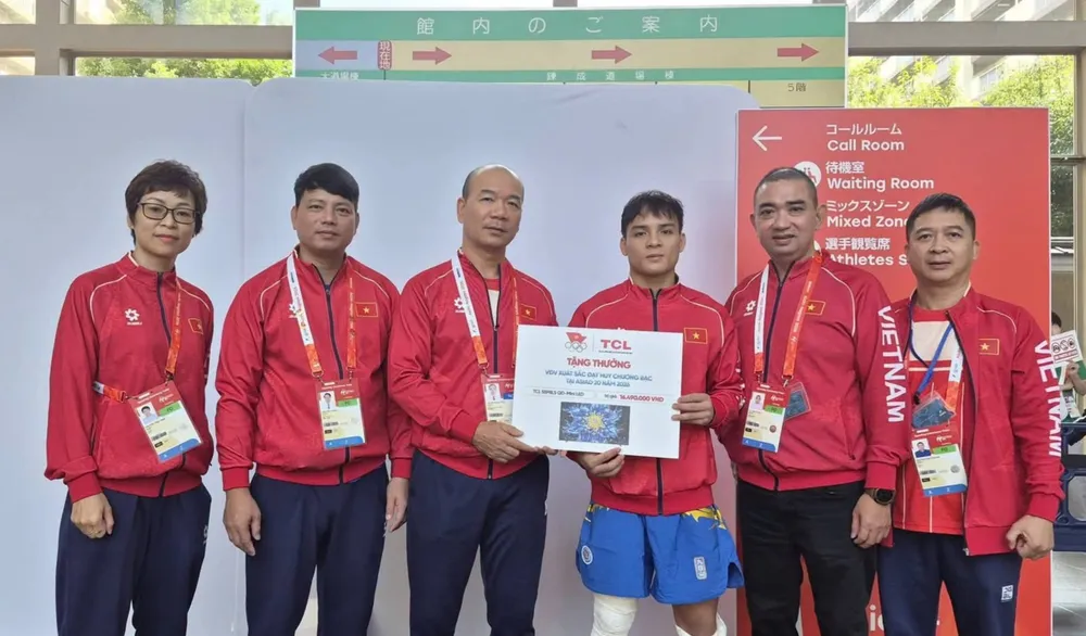 Đinh Văn Tâm (giữa) nhận thưởng từ đoàn thể thao Việt Nam sau tấm HCB ASIAD 20