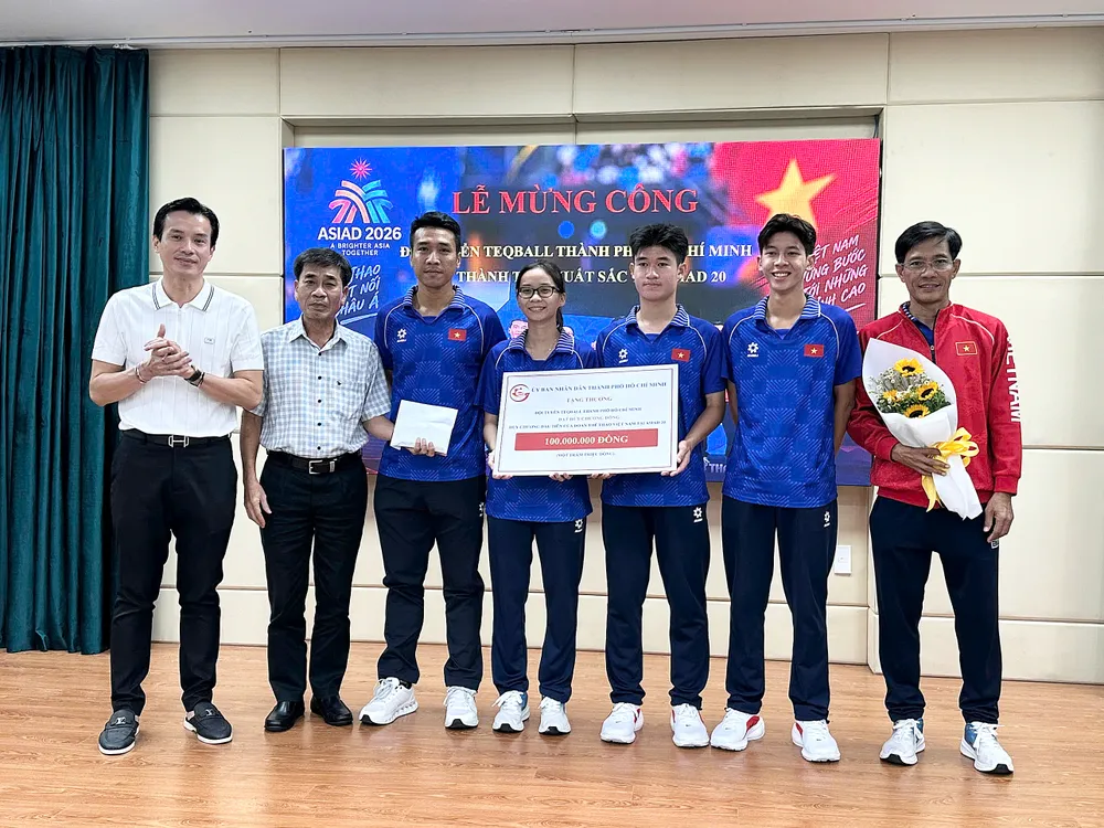 Phó Giám đốc Sở VH-TT TPHCM Nguyễn Nam Nhân (trái) trao 100 triệu đồng, phần thưởng từ UBND TPHCM cho thành viên đội tuyển teqball. Ảnh: THANH TÙNG 