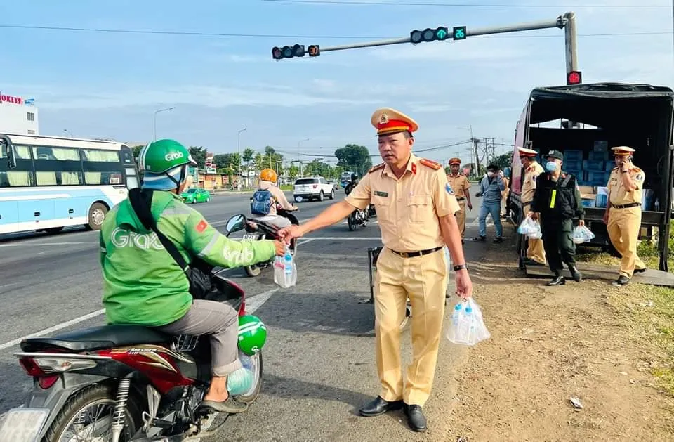 Lực lượng cảnh sát giao thông hỗ trợ nước suối cho người dân đi đường. Ảnh: Người Đồng Nai Lực lượng cảnh sát giao thông hỗ trợ nước suối cho người dân đi đường. Ảnh: Người Đồng Nai