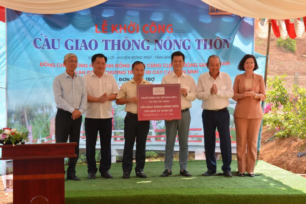 Nguyên Ủy viên Bộ Chính trị, nguyên Phó Thủ tướng Thường trực Chính phủ Trương Hòa Bình và Phó Chủ tịch UBND TPHCM Võ Văn Hoan cùng đại diện nhà tài trợ trao biểu trưng tặng cầu giao thông nông thôn cho lãnh đạo tỉnh Bình Phước