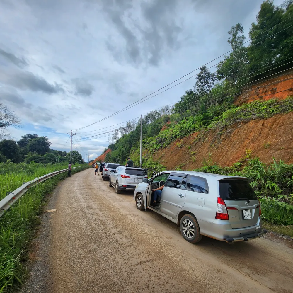 Xe du lịch phải tạm dừng vì tắc đường do sạt lở đất đá.jpg