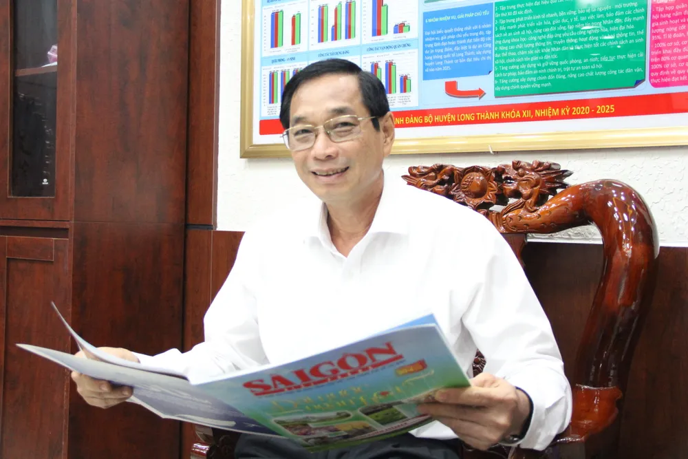 Ảnh 3 Bí thư Huyện ủy Long Thành Võ Văn Phi đọc báo Đặc san SGGP.JPG