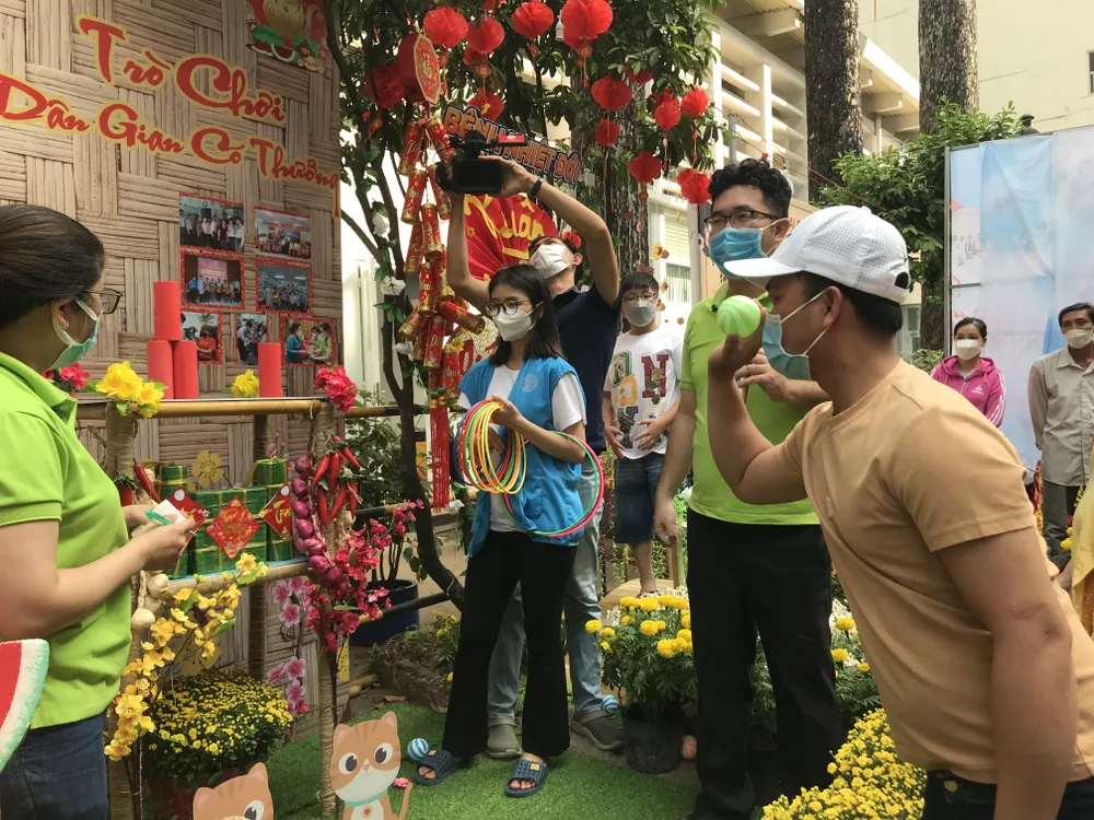 Một người nhà bệnh nhân hào hứng tập trung thi ném banh sau 5 phút xếp hàng chờ tới lượt.