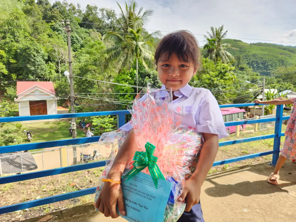 Một em học sinh vui mừng khi có cặp, đồng phục mới