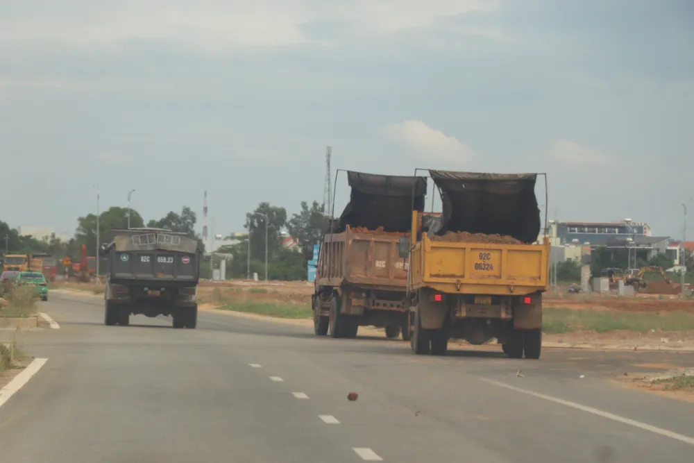 2 xe tải nhận đất từ mỏ Đại Sơn đến tập kết ở một khu đô thị ven đường Võ Chí Công (huyện Núi Thành, tỉnh Quảng Nam)