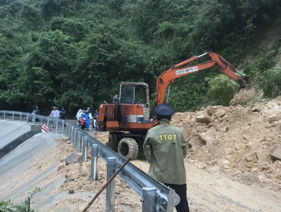 Lực lượng chức năng san gạt, dọn đất đá sạt lở trên đèo Le để thông tuyến ĐT611. Ảnh: Sở GTVT