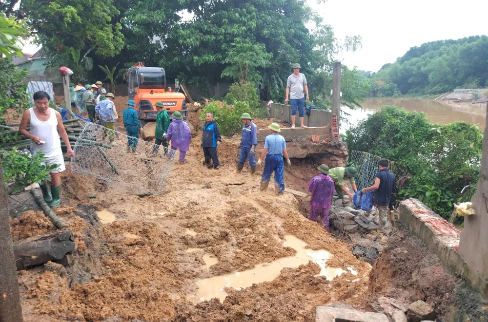 Người dân và lực lượng chức năng gia cố sạt lở bờ sông Ngân Mỹ ở xã Cẩm Duệ (huyện Cẩm Xuyên, tỉnh Hà Tĩnh). Ảnh: DƯƠNG QUANG