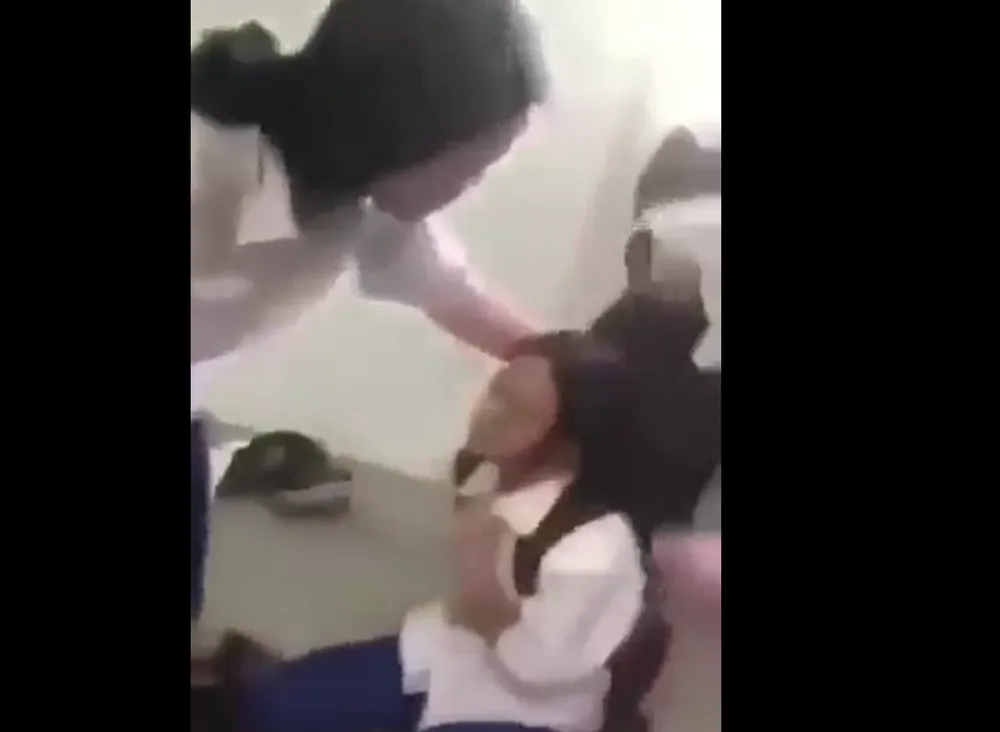 Nữ sinh bị nhóm bạn đánh đập. Ảnh cắt từ video