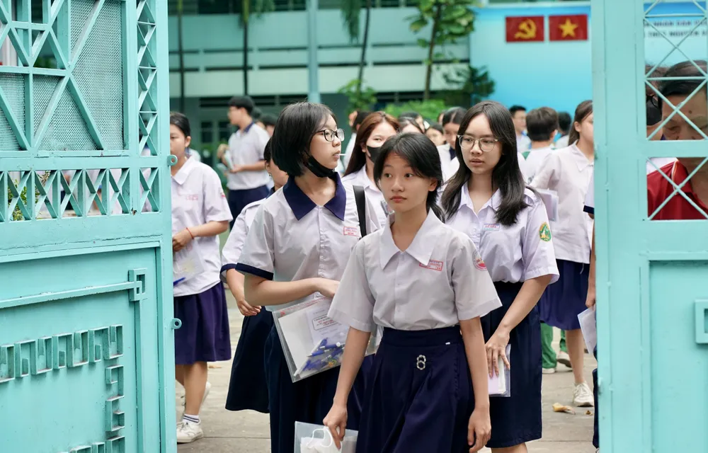 Các thí sinh đầu tiên bước ra sau khi thi môn Ngoại ngữ tại điểm thi trường THCS Nguyễn Văn Phú, quận 11. Ảnh: HOÀNG HÙNG