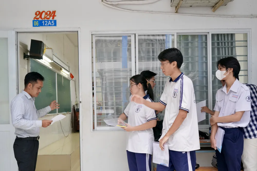 Thí sinh làm thủ tục dự thi tại phòng thi, điểm thi Trường THPT Bùi Thị Xuân, quận 1. Ảnh: HOÀNG HÙNG