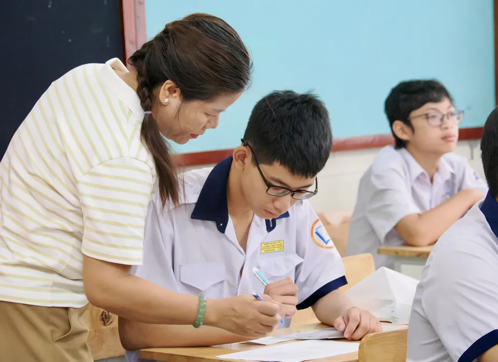 Giám thị hướng dẫn thí sinh rà soát thông tin cá nhân, hoàn tất thủ tục dự thi trước Kỳ thi tuyển sinh vào lớp 10 THPT năm học 2026-2027 tại điểm thi Trường THPT Lương Thế Vinh, phường Cầu Ông Lãnh. ẢNH: HOÀNG HÙNG.