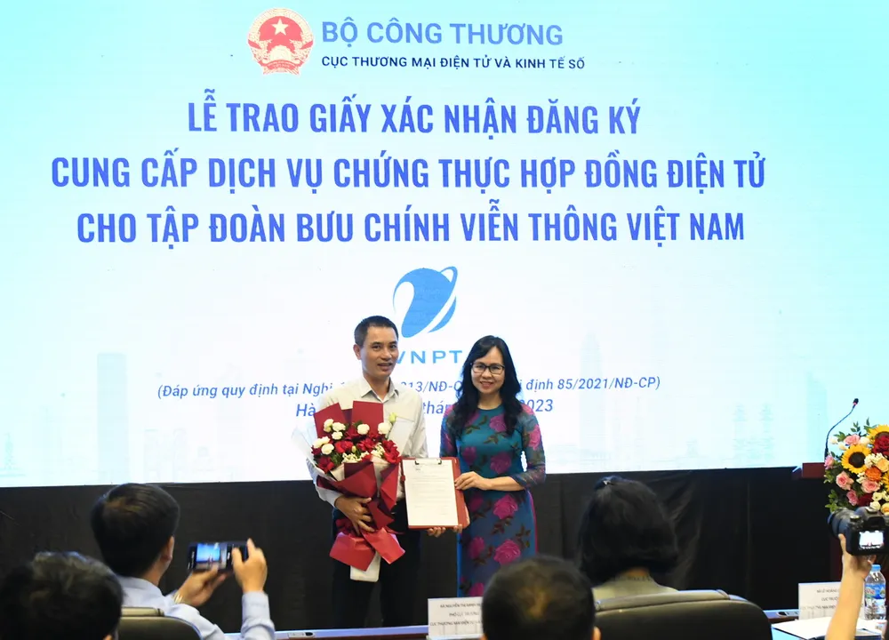 Bà Lê Hoàng Oanh, Cục trưởng Cục Thương mại điện tử và Kinh tế số trao giấy xác nhận đăng ký cung cấp dịch vụ chứng thực hợp đồng điện tử cho đại diện Tập đoàn VNPT