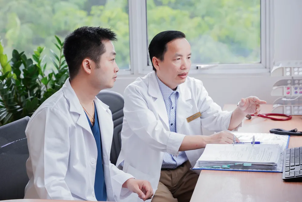 TS.BS Đặng Quang Huy và ThS.BS Lê Văn Bình trao đổi về tình hình bệnh nhân sau cuộc đại phẫu TS.BS Đặng Quang Huy và ThS.BS Lê Văn Bình trao đổi về tình hình bệnh nhân sau cuộc đại phẫu