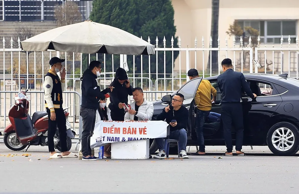 Một nhóm phe vé trước sân Mỹ Đình đã bán được vé "chợ đen" cho người đi ô tô. ẢNH: HỮU THÀNH