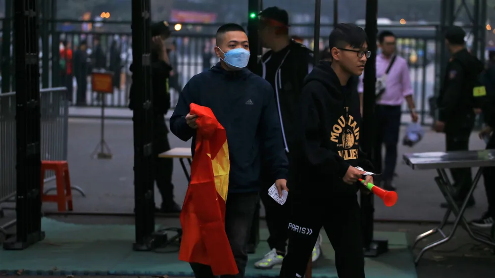 Người hâm mộ qua khu vực kiểm tra an ninh để tiến vào bên trong sân