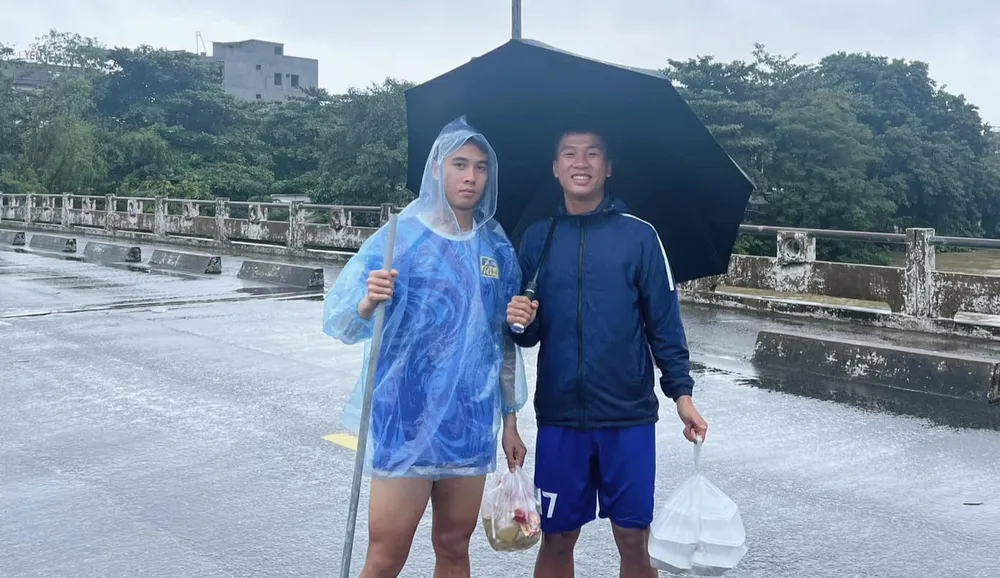 Cầu thủ Huế lội nước đi mua đồ ăn dự trữ. ẢNH: TÂM HÀ 