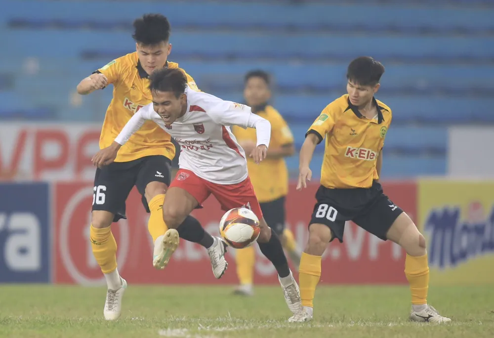 Các cầu thủ Hòa Bình (áo vàng) đầy vất vả ở trận đấu gặp đội khách Long An. ẢNH: MINH HOÀNG 