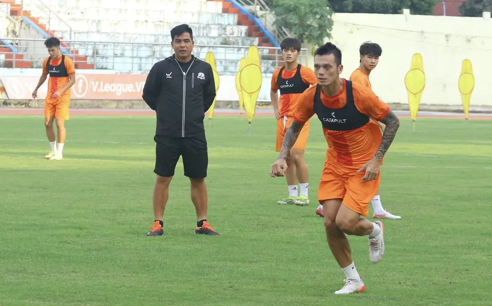 HLV Nguyễn Việt Thắng (áo đen) cùng các cầu thủ Ninh Bình có chuyến làm khách khó khăn tại Bình Phước. ẢNH: MINH ĐỨC