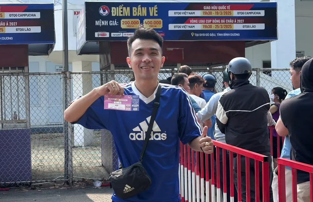 Cổ động viên tại Bình Dương vui mừng cầm trên tay tấm vé xem trận giao hữu Việt Nam - Campuchia. ẢNH: TÂM HÀ 