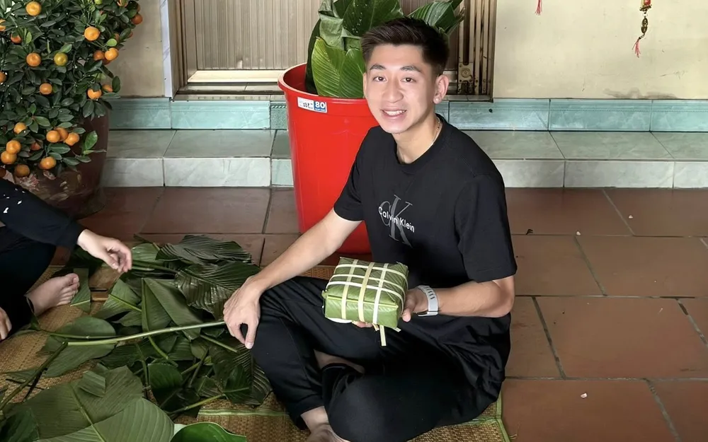 Trung vệ Nguyễn Nhật Minh gói bánh chưng cùng gia đình. ẢNH: FBNV 