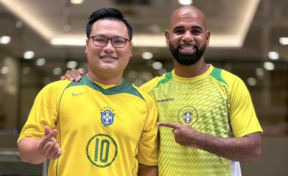 Cựu Vua phá lưới V-League Claudecir Junior (phải) cùng một người hâm mộ Việt Nam yêu mến Brazil. ẢNH: TÂM HÀ 