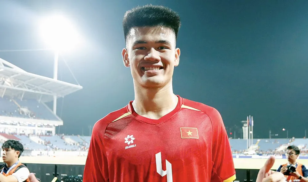 Tuyển thủ Đinh Quang Kiệt vinh dự khi được cầm cờ Việt Nam tại lễ khai mạc ASIAD 2026. ẢNH: ANH KHOA 