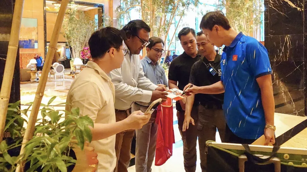 Người hâm mộ xin chữ ký HLV Kim Sang-sik. ẢNH: NHẬT ĐOÀN