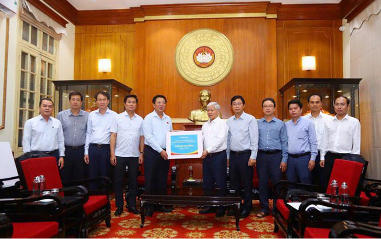 建设部领导向越南祖国阵线中央委员会主席杜文战移交捐款。