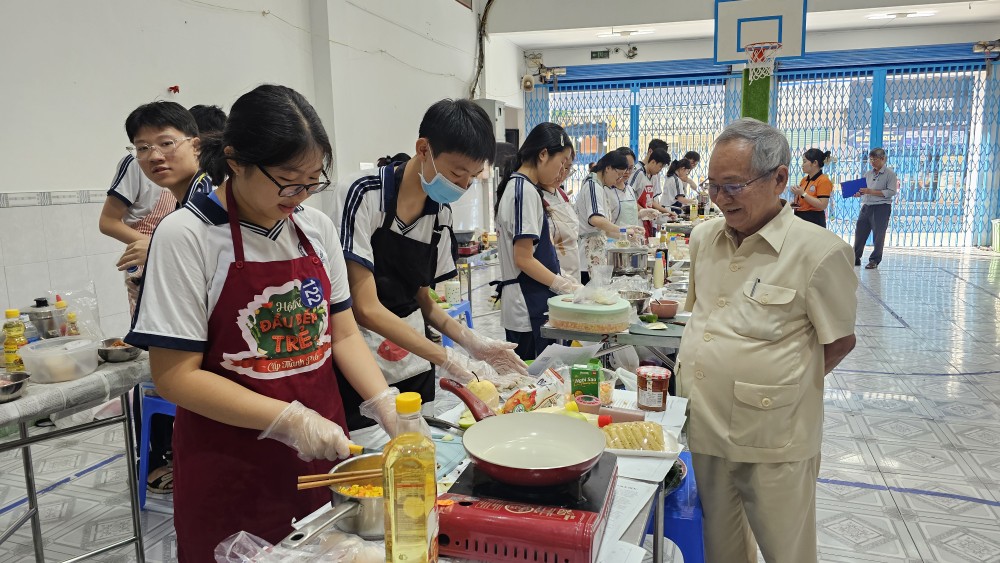 文朗学校校委主席阮曰朗观看学生烹饪比赛。