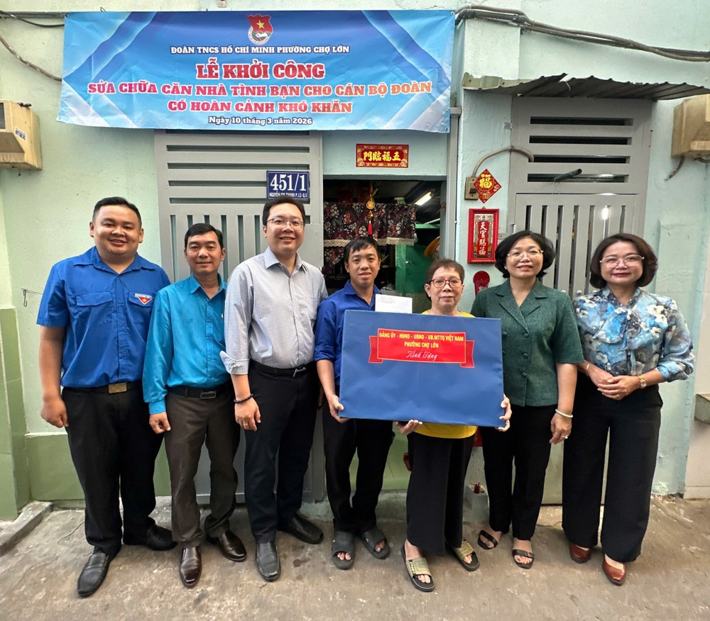 堤岸坊党委书记、坊人民议会主席黄玉女芳红（右二）向华人青年张伟泉赠送礼物。