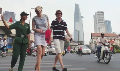 旅游秩序维护员热心协助游客过马路。