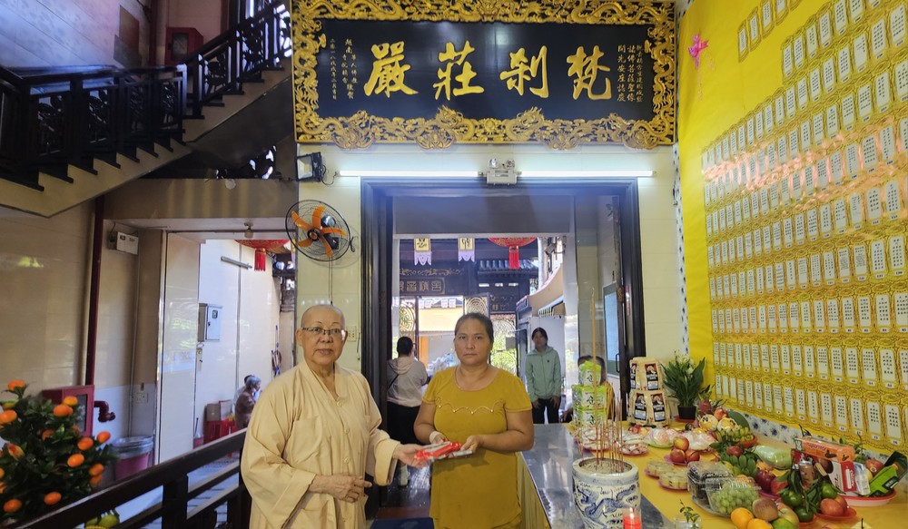 观音精舍监院释振净（悟净）法师向贫困户派发生活辅助费。图：心雨