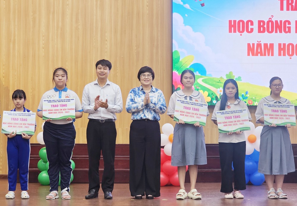 坊党委书记张明娇，坊越南祖国阵线委员会主席阮廷贵颁发奖助学金给越、华贫困学生。图：心雨