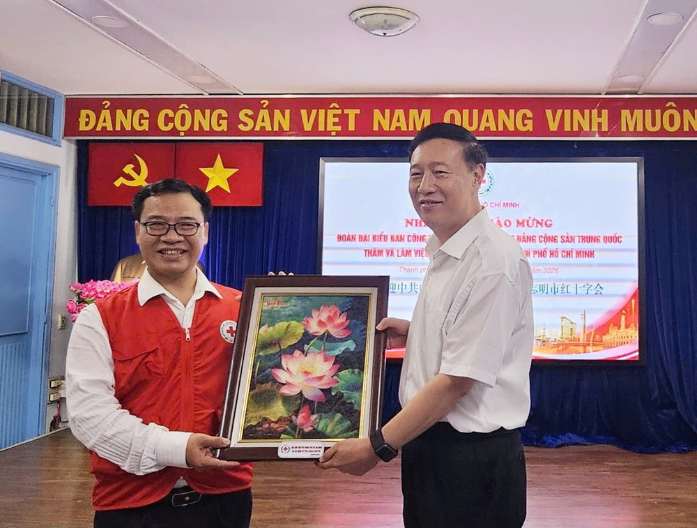 胡志明市红十字会主席阮明日向中国共产党中央社会工作部副部长赵世堂赠送礼物。图：心雨