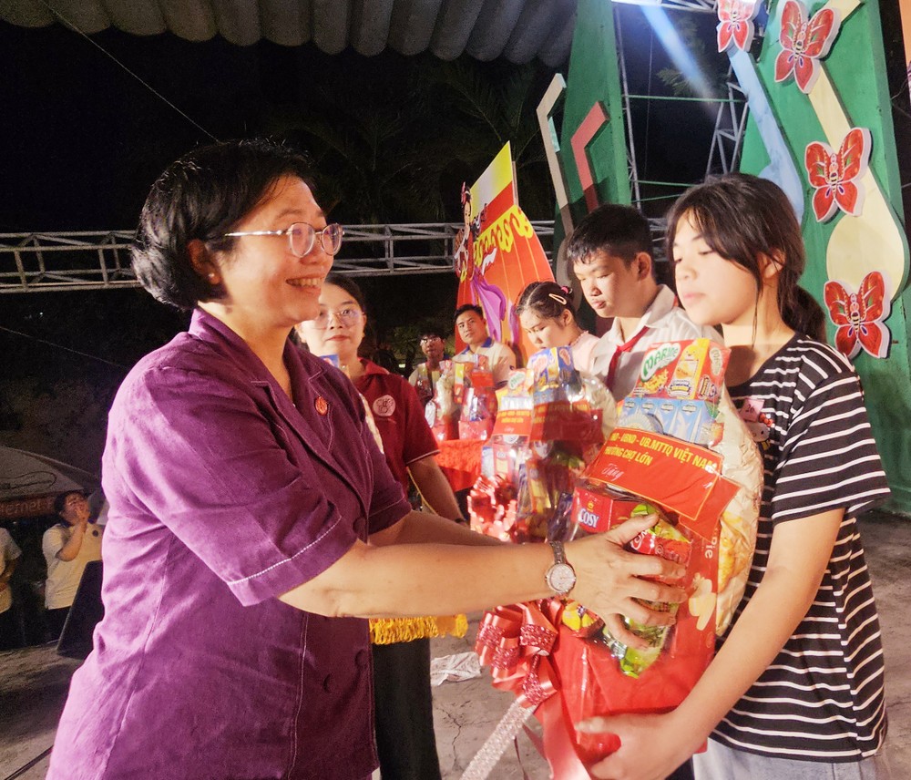 堤岸坊党委书记黄玉女芳红向贫困子弟赠送礼物。图：心雨