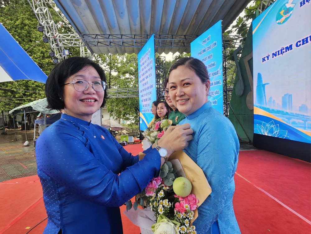 坊党委书记黄玉女芳红向华人妇女吳丽株颁发纪念章。图：心雨