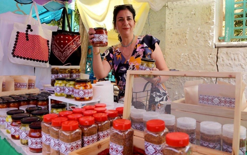 一位女士展示自制果酱。（图取自人民网）