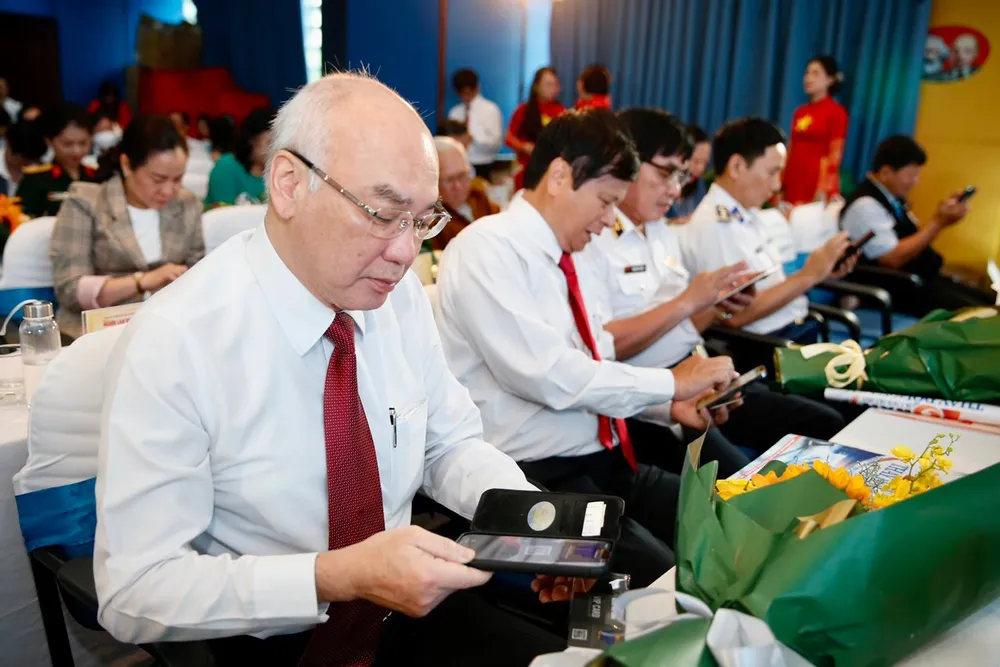 Đại biểu trải nghiệm ứng dụng đọc báo VIP trên nền tảng số của Báo Người Lao Động