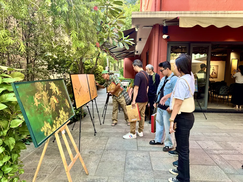 Người tham dự chiêm ngưỡng bản in các tác phẩm nổi bật của họa sĩ Trần Phúc Duyên.JPG